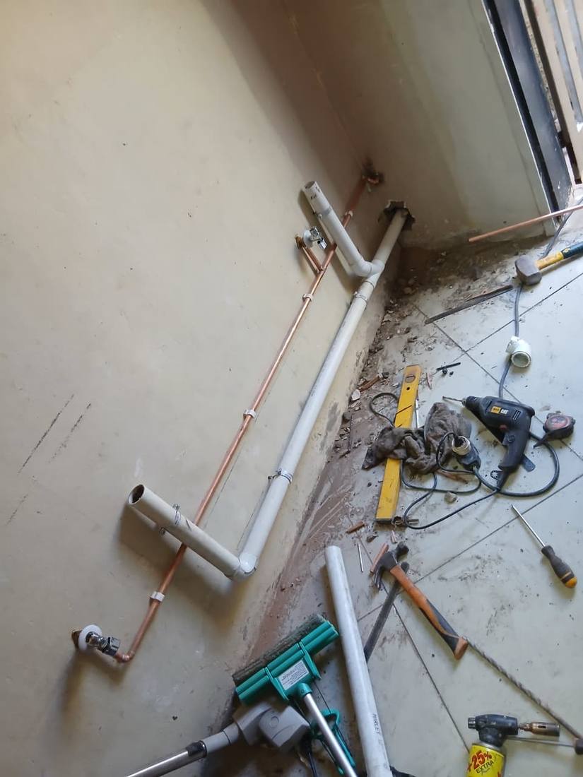 Copper and PVC rough-in plumbing set out on site with tools laid ready