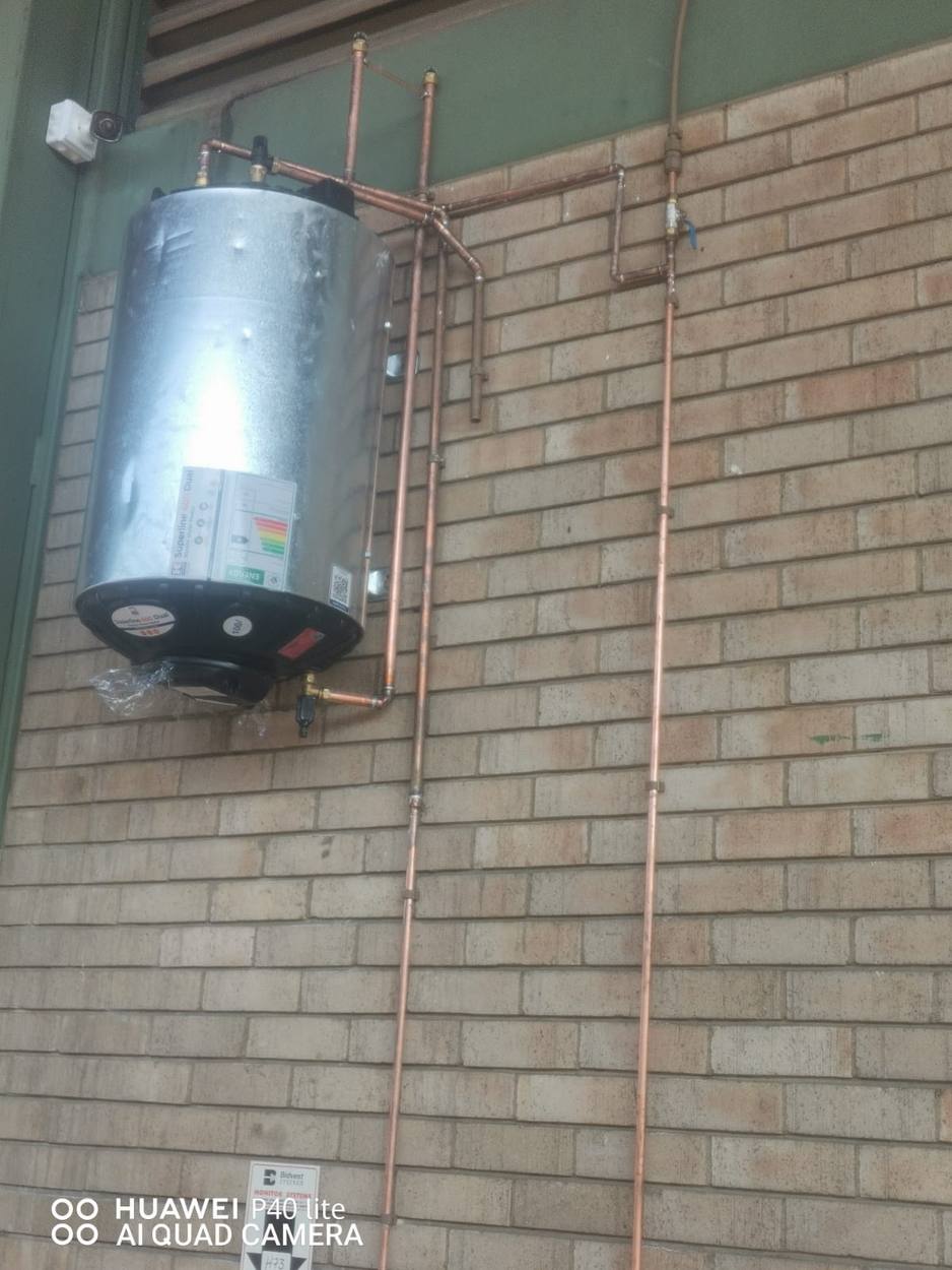 Geyser installed on an exterior brick wall in Midrand with neat copper hot and cold pipework by New Generation Plumbing