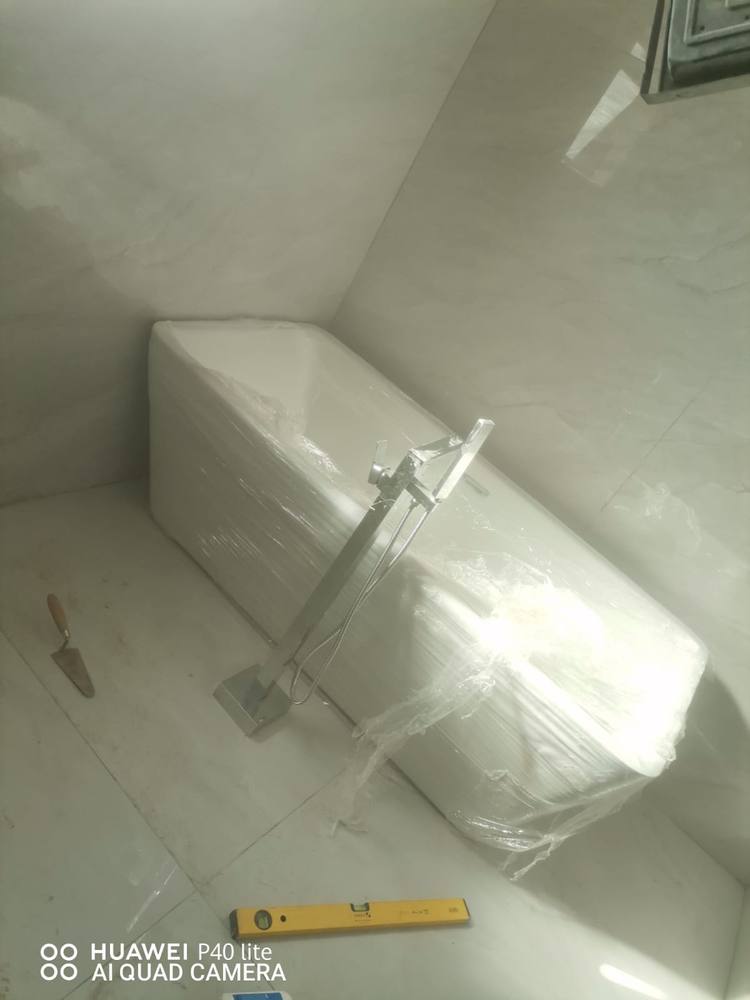 Newly installed bath with a floor-mounted mixer in a finished bathroom