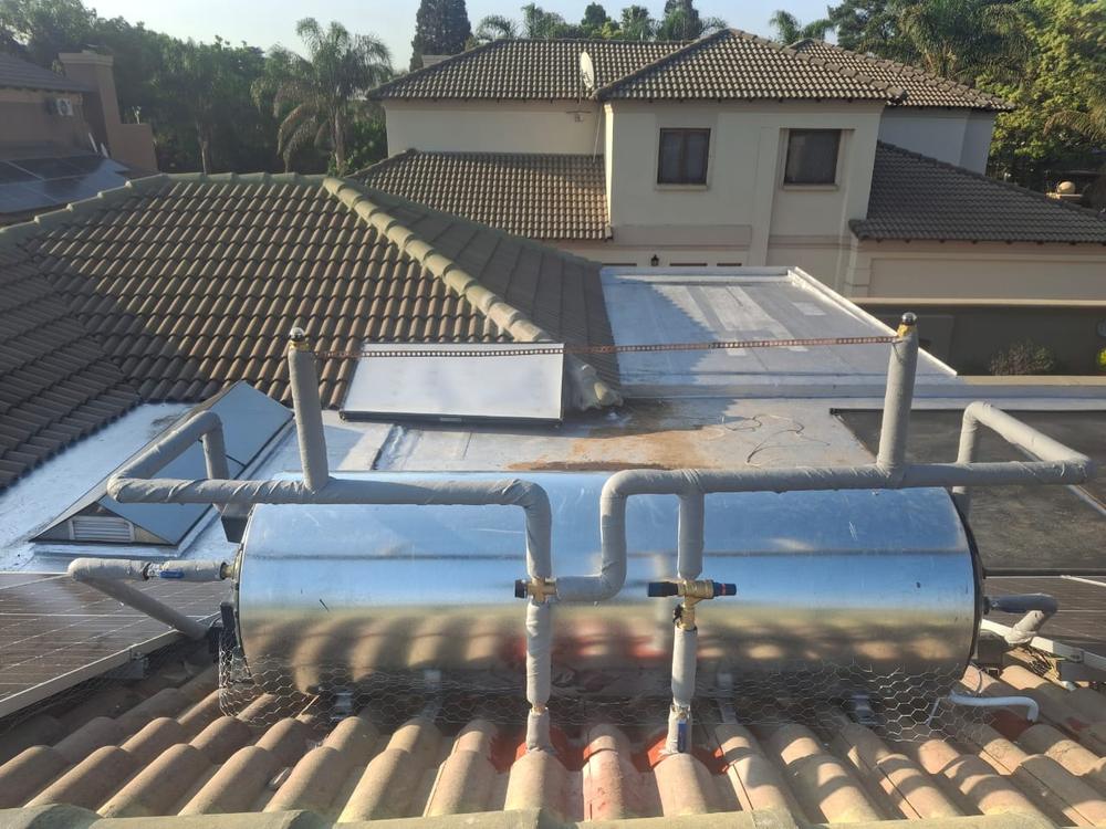 Compliant geyser installation on a roof with correctly fitted safety valves and overflow pipework