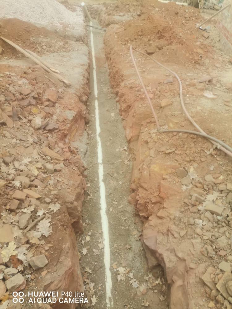 New water main laid and bedded in sand inside an excavated trench